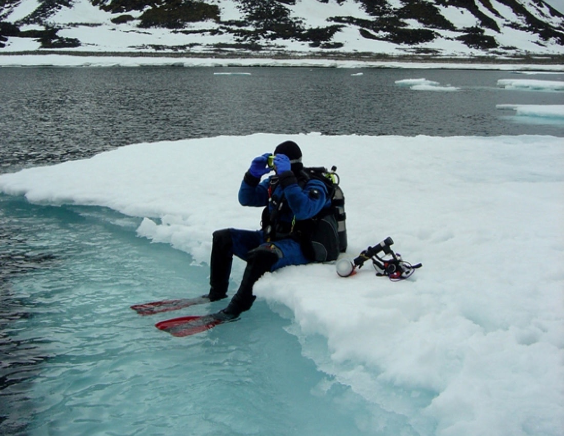 Diver sits on the ice with his kit