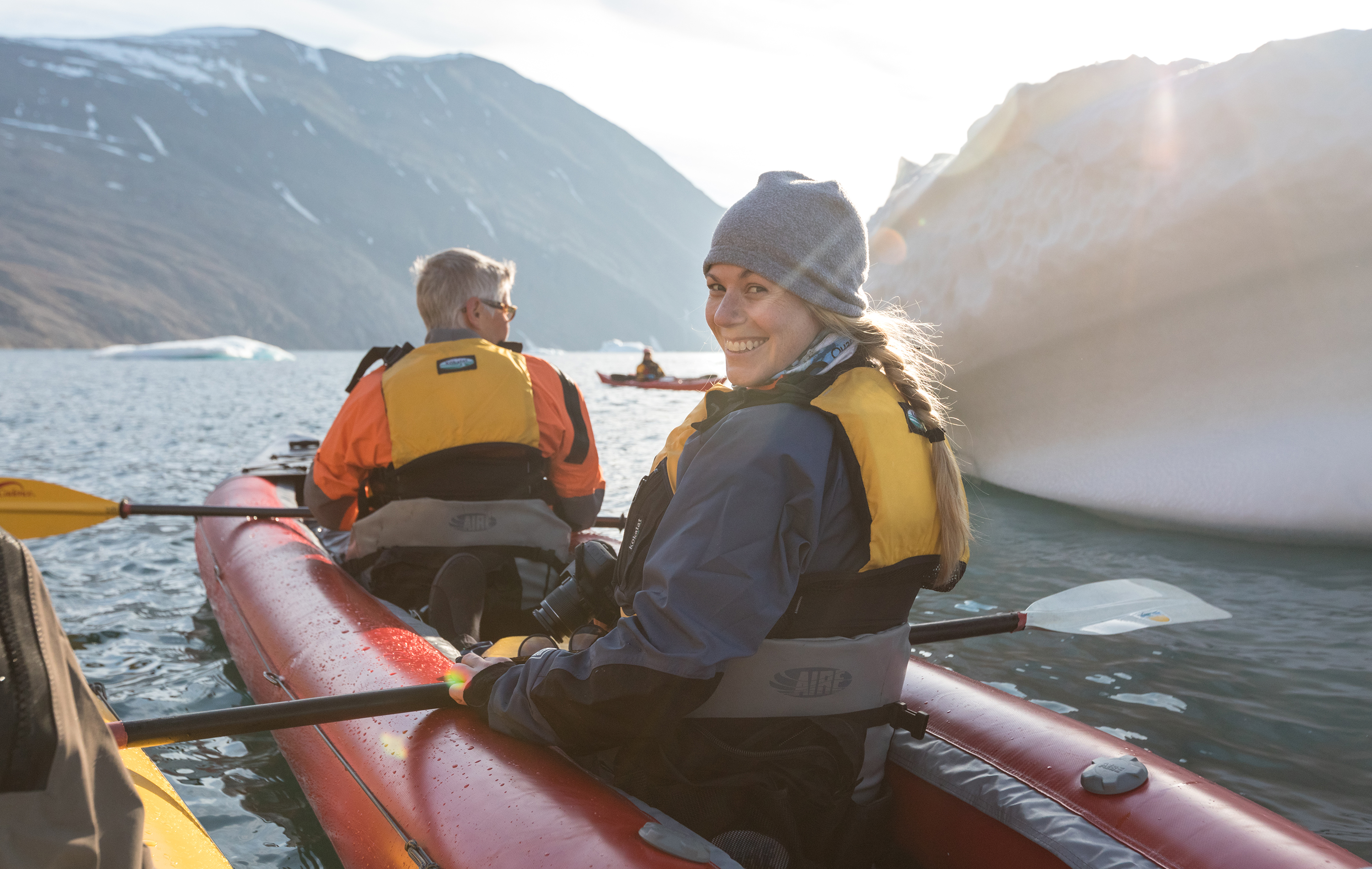A woman looks back as she kayaks in East Greenland
