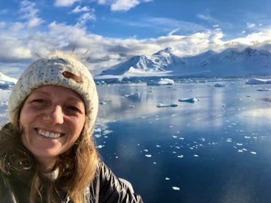 A smiling woman surrounded by icy Antarctic scenery