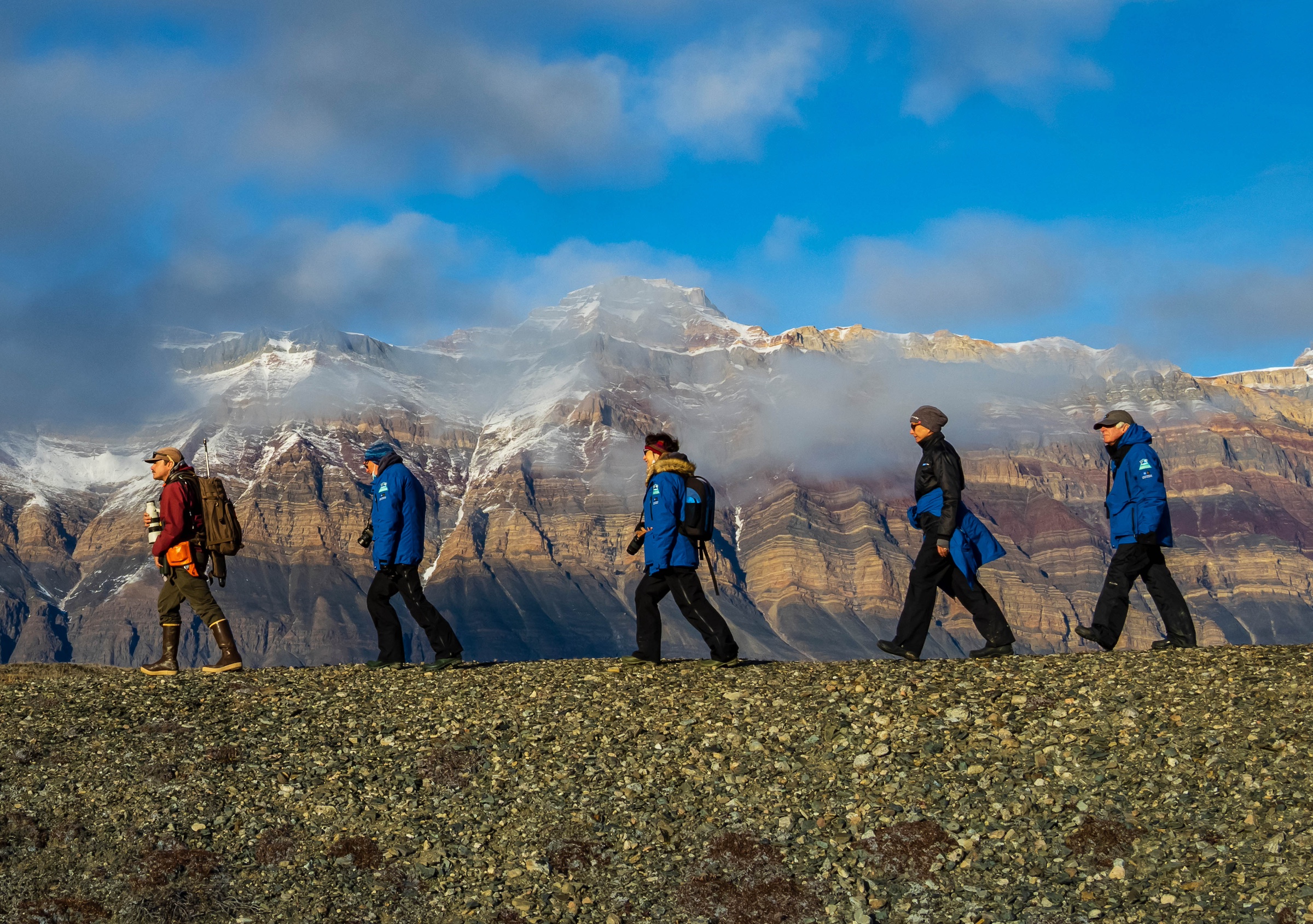 Guests hike and explorers on shore of Alpejord Fjord, Northeast Greenland National Park, Greenland
