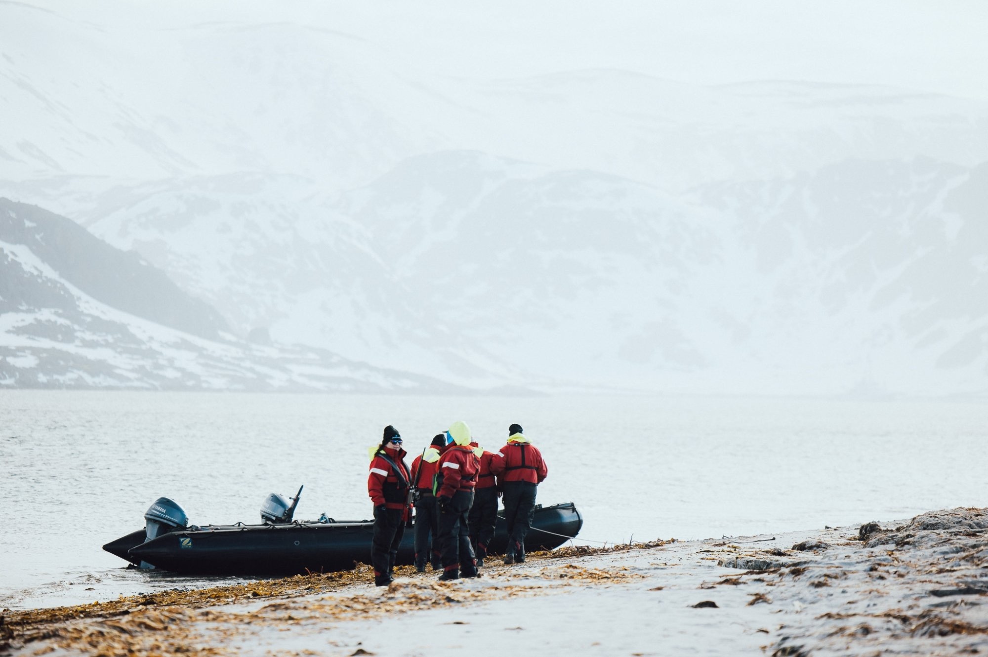 A zodiac boat lands on the shore in Svalbard